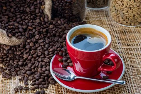 Cup of coffee on coffee beans background on a wooden table Stock Photos