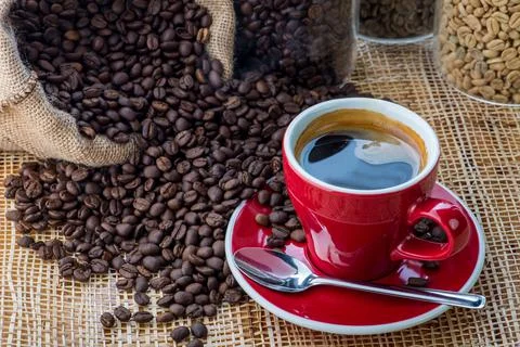 Cup of coffee on coffee beans background on a wooden table Stock Photos