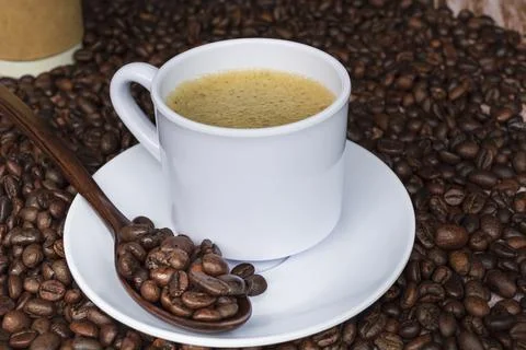 Cup of coffee on coffee beans background. Stock Photos
