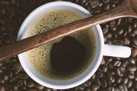 Cup of coffee on coffee beans background. Stock Photos