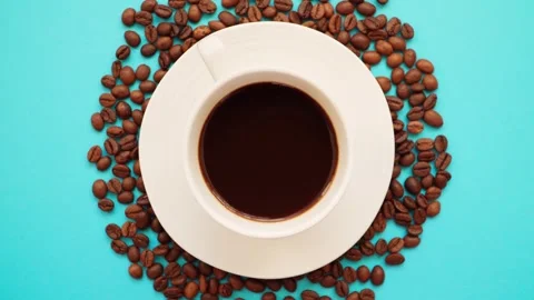 A cup of coffee with coffee beans on a bright blue background. Stock Footage 261990811
