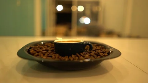 A cup of coffee with coffee beans in the plate with blurred background Stock Footage 125927261