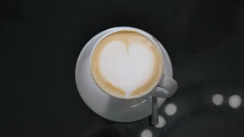 A cup of coffee with coffee foam appears in the center of the frame. Stock Footage 221420199