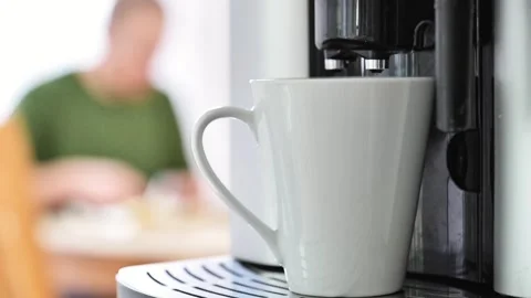 Cup of coffee in a coffee machine on a man preparing sandwiches at a table Stock Footage 263755442