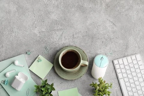 Cup of coffee with computer keyboard, mouse and earphones on grey grunge back Stock Photos