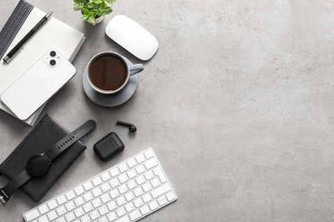 Cup of coffee with computer keyboard, mouse and mobile phone on grey grunge b Stock Photos