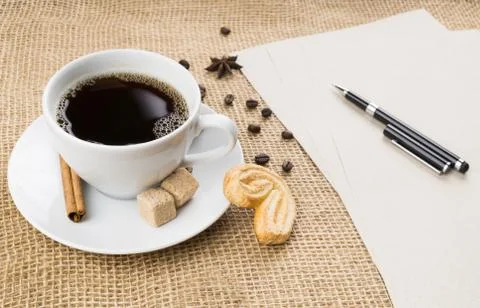 Cup of coffee, cookie, pen and paper on sackcloth background Stock Photos
