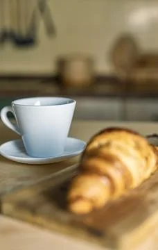 Cup of coffee with croissant on a rustic kitchen table. Fresh croissants in.. Foto stock