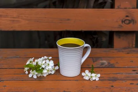 A cup of coffee on a dark, worn rustic wooden table. The composition is decor Stock Photos