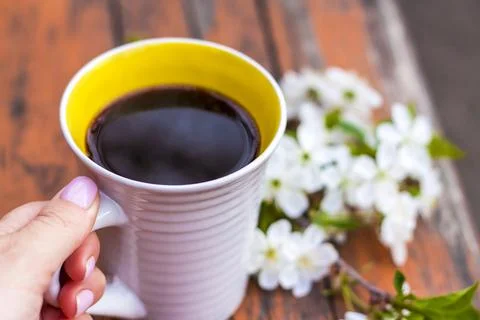 A cup of coffee on a dark, worn rustic wooden table. The composition is decor Stock Photos