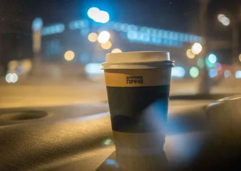 A cup of coffee is on the dashboard of the car Stock Photos