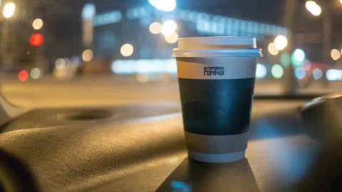 A cup of coffee is on the dashboard of the car Stock Photos