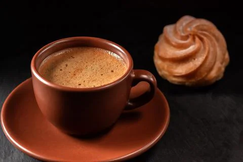Cup of coffee with eclairs on a stone background. Top view with copy space for Foto stock