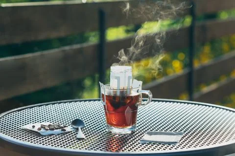 Cup of coffee, empty drip coffee bags, steam rises above the mug Foto stock