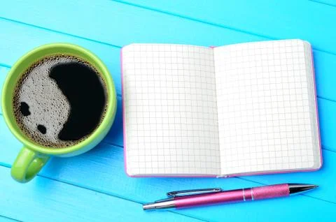 Cup of coffee with empty notebook on table Stock Photos