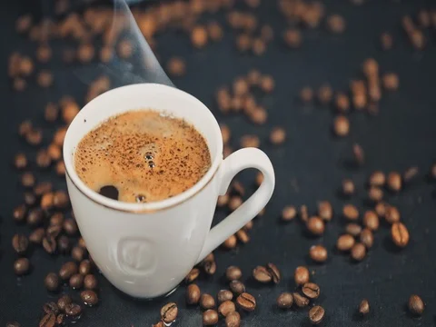 A Cup of Coffee. Falling grains of coffee on the table. Slow motion Video stock 73669984