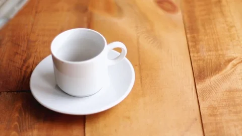 A cup of coffee is filled with hot coffee on wooden background Stock Footage 82158517