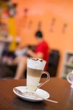 Cup of coffee with flower lobe pattern in reveal cup on wooden table. Stock Photos