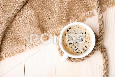 Cup of coffee with foam on wooden table Stock Photos