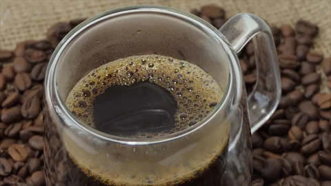 Cup of coffee with fresh roasted coffee beans background. A filled transparent Stock Footage 195900894