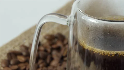 Cup of coffee with fresh roasted coffee beans background. A filled transparent Stock Footage 196188267