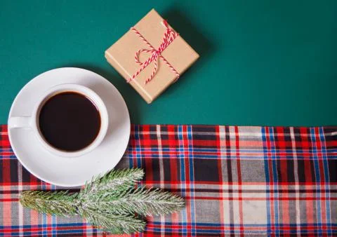 Cup of coffee, gift box, pine branch on the green background with checkered n Stock Photos