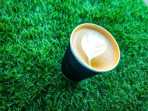 Cup of coffee on the green grass Stock Photos