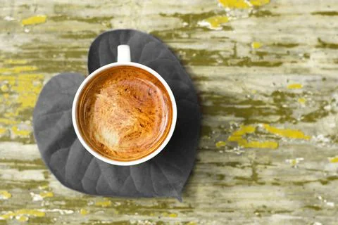 A cup of coffee on the green leaf. Stock Photos