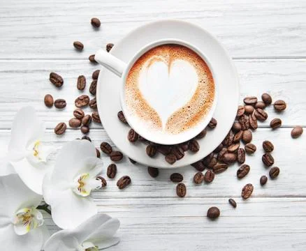 A cup of coffee with heart pattern on a table Stock Photos