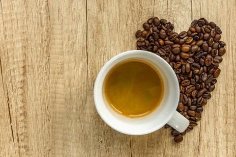 Cup of Coffee with Heart Shape Made of Coffee Beans on Wooden Background Stock Photos
