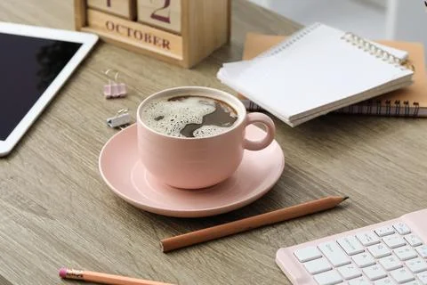 Cup of coffee with keyboard, tablet computer and stationery on wooden table i Stock Photos