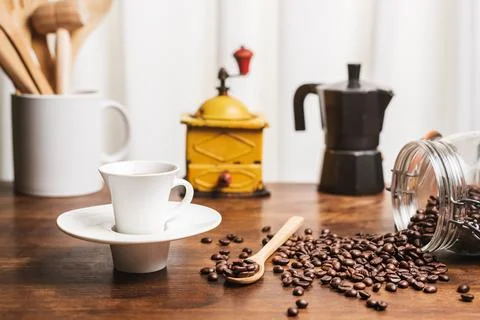 Cup of coffee on a kitchen table with a jug with wooden utensils, a coffee .. Stock Photos