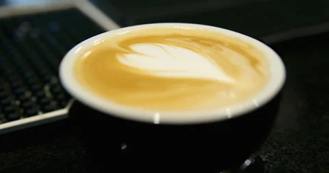 Cup of coffee with latte art pattern milk foam Stock Footage 265554166
