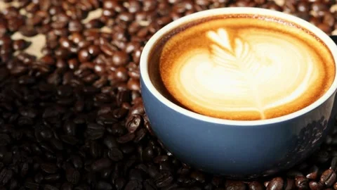 A Cup of coffee with latte art on top of coffee beans. 動画素材 334648857