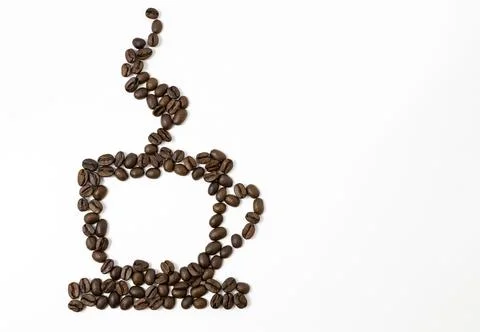 A cup of coffee is lined with coffee beans. Place for text. 库存照片