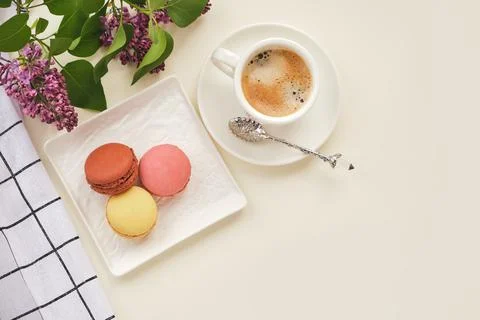 Cup of coffee with macaroons on a table with flowers Stock Photos