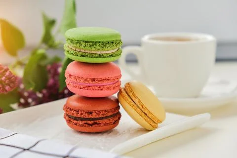 Cup of coffee with macaroons on a table with flowers Stock Photos