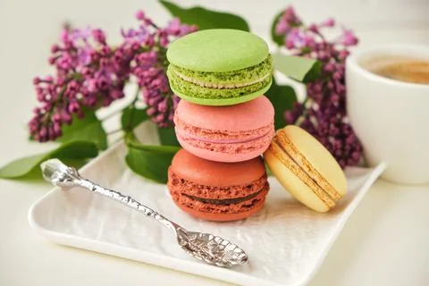Cup of coffee with macaroons on a table with flowers Stock Photos
