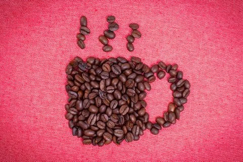 A cup of coffee make from coffee beans on red cloth background Stock Photos