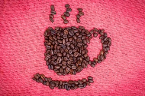 A cup of coffee make from coffee beans on red cloth background Stock Photos