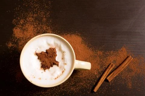 Cup of coffee with maple leaf pattern of cinnamon Stock Photos