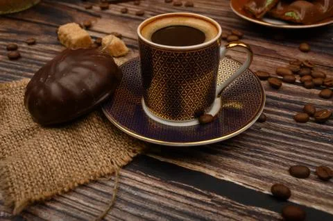A Cup of coffee, marshmallows in chocolate, coffee beans, brown sugar on a wo Stock Photos