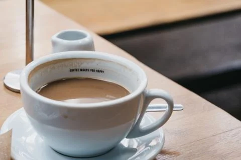 Cup of coffee with a message "Coffee makes you happy" inside. Stock Photos