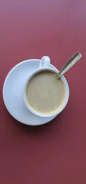 Cup of coffee with milk on a red background. Stock Photos