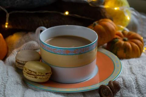 A cup of coffee with milk with two macaroons on a white knitted sweater Stock Photos