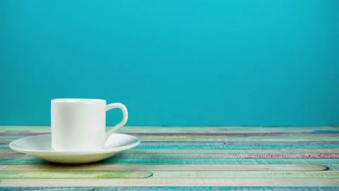 A cup of coffee moves like a car on a blue background. Stop motion Stock Footage 169536617
