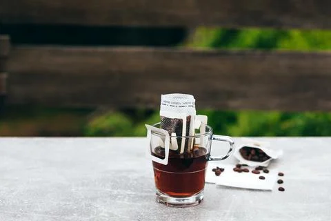 Cup of coffee, next to empty drip coffee bags and arabica coffee beans Foto stock