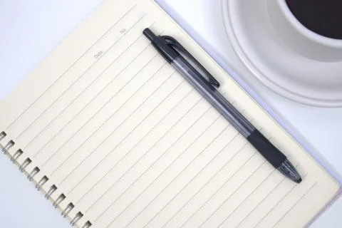 Cup of coffee, notebook and pen on white table Stock Photos
