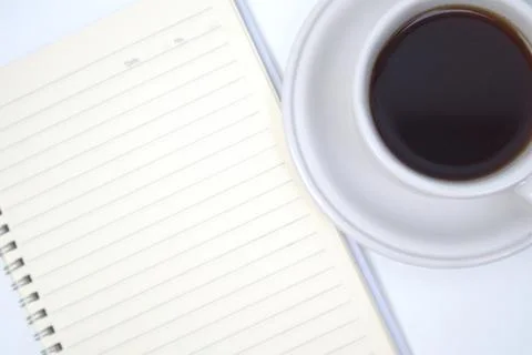 Cup of coffee, notebook and pen on white table Stock Photos