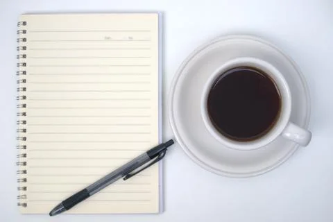 Cup of coffee, notebook and pen on white table Stock Photos